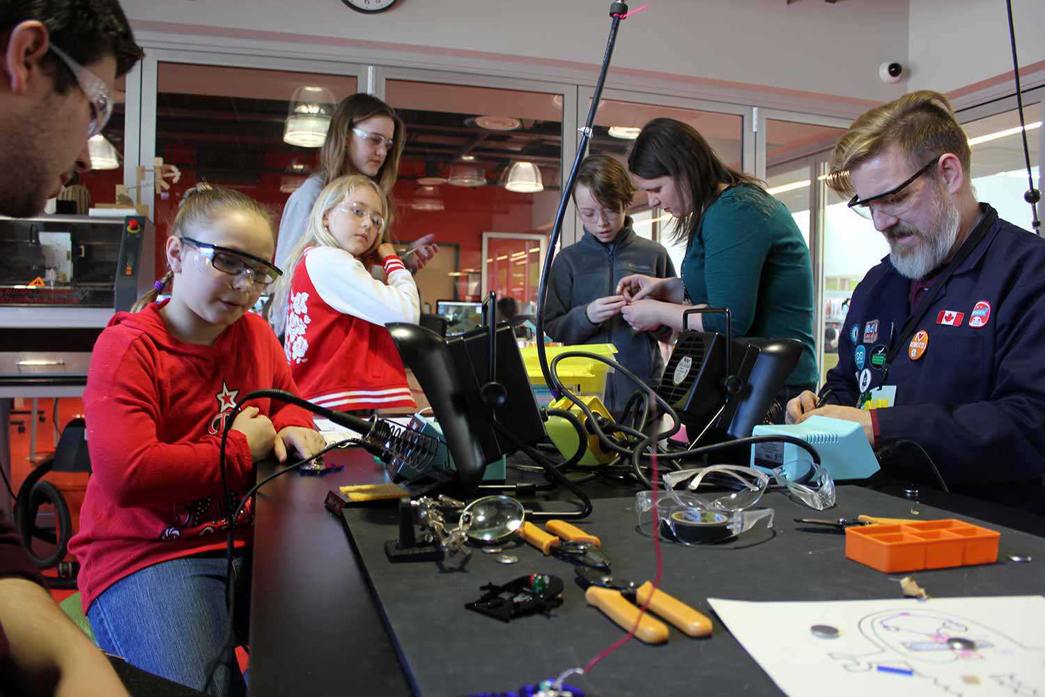 Des employés et un groupe d’enfants travaillent au hackLAB à la bibliothèque et ideaLAB d’Innisfil